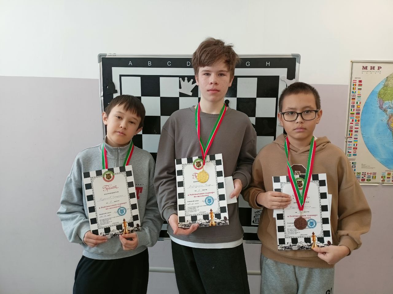 Трое учеников с медалями и дипломами